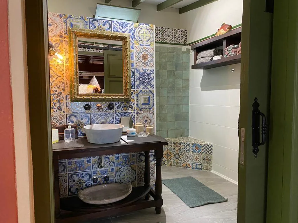 Baño con azulejos hidráulicos de colores y espejo dorado antiguo, Finca Cebollino