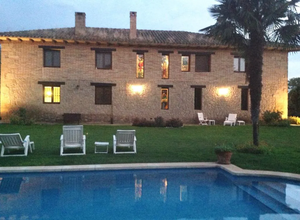 Casa de piedra iluminada junto a la piscina