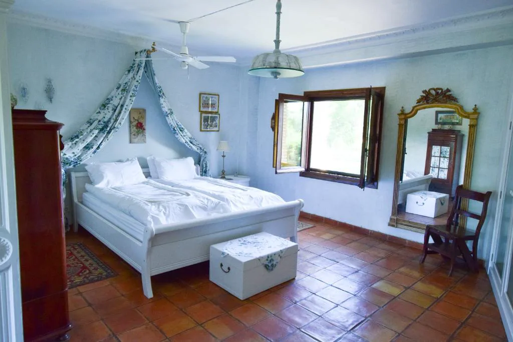 Habitación con cama blanca y detalles azules