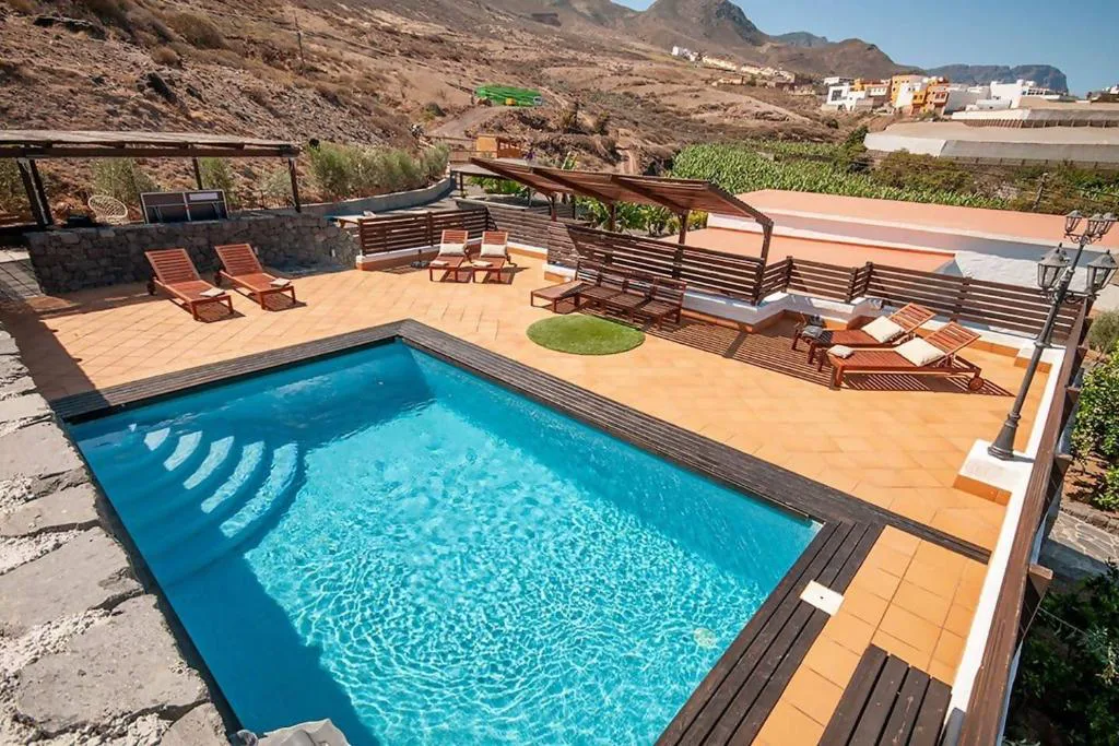 Piscina privada junto a un muro de piedra volcánica con vistas a las plataneras, Finca Jardín del Norte, Gáldar