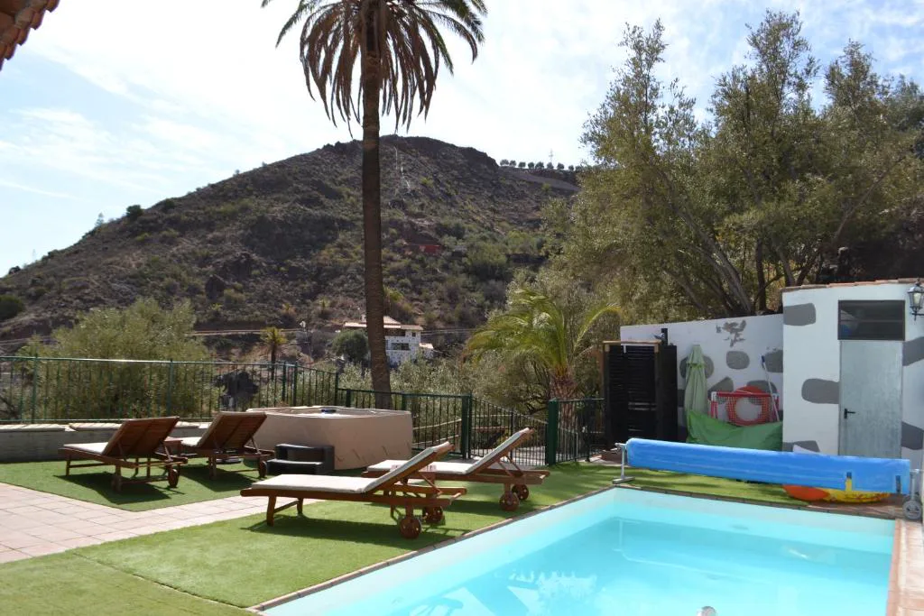 Piscina con tumbonas de madera frente a las montañas de Fataga, Finca Mariola