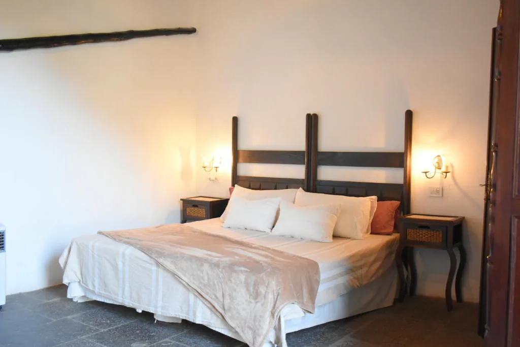 Dormitorio con cabecero de madera tallada tradicional canaria, Finca Mariola