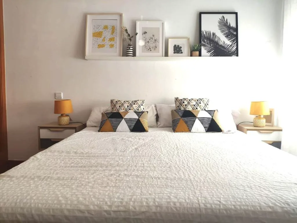 Dormitorio con cama doble y cuadros