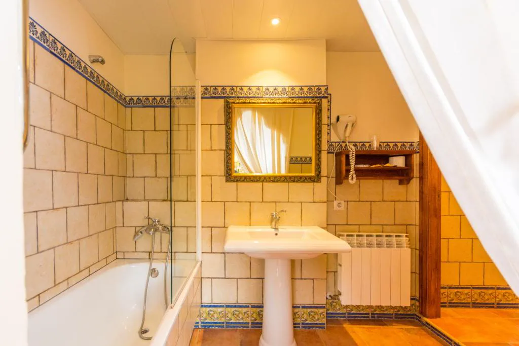 Baño con bañera y paredes de azulejo