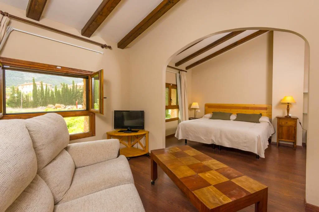Habitación con sofá blanco y ventana al campo