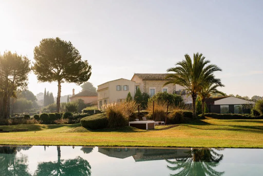Jardín con piscina exterior y edificio de piedra de Fontsanta Hotel, Mallorca