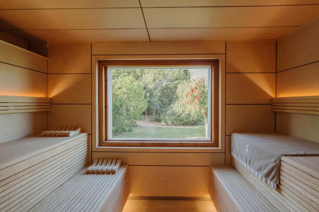 Sauna de madera con ventanal al jardín de Fontsanta Hotel Thermal & Spa