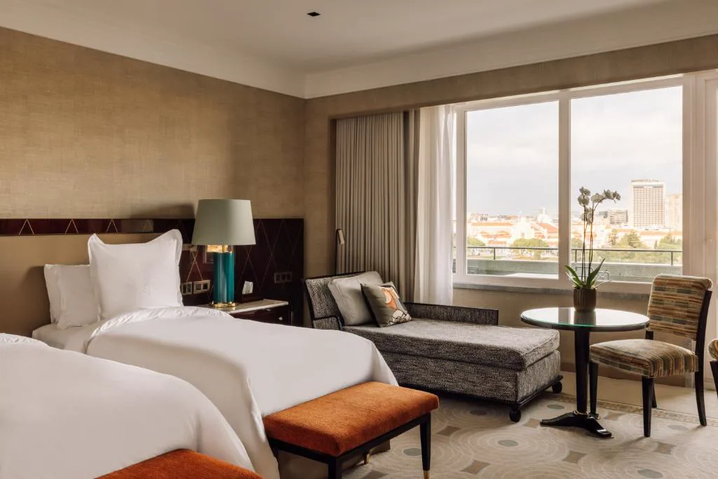 Habitación con banqueta naranja y vistas a los tejados de Lisboa, Four Seasons Ritz Lisbon