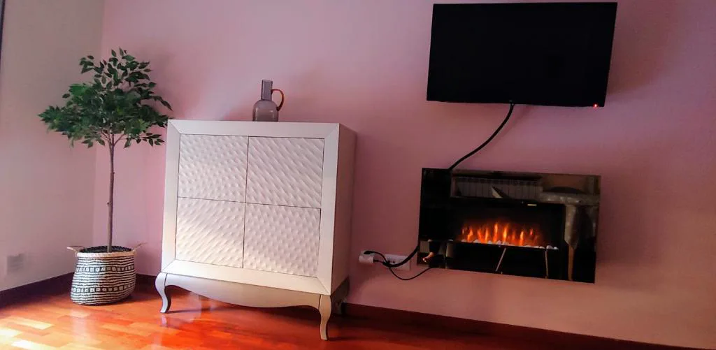 Salón con sofá gris y televisor