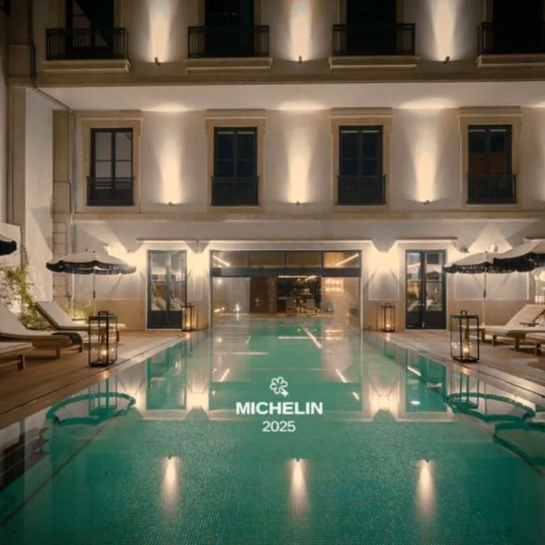 Piscina exterior con distintivo Michelin junto a la fachada del GA Palace, Oporto