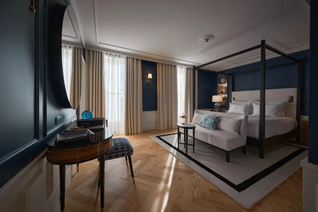 Suite en azul marino con cama con dosel y espejo circular, GA Palace