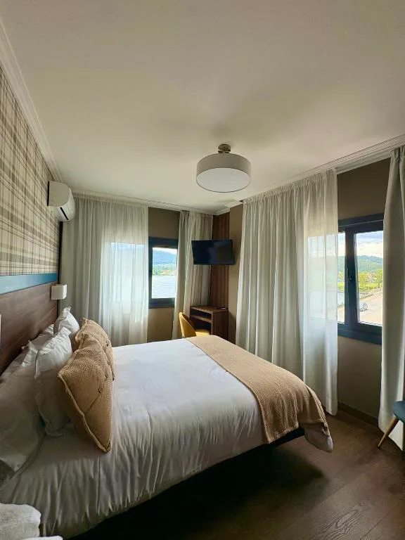 Dormitorio con vistas a la Ría de Vigo y cortinas blancas, Hotel SPA GBC Arcade