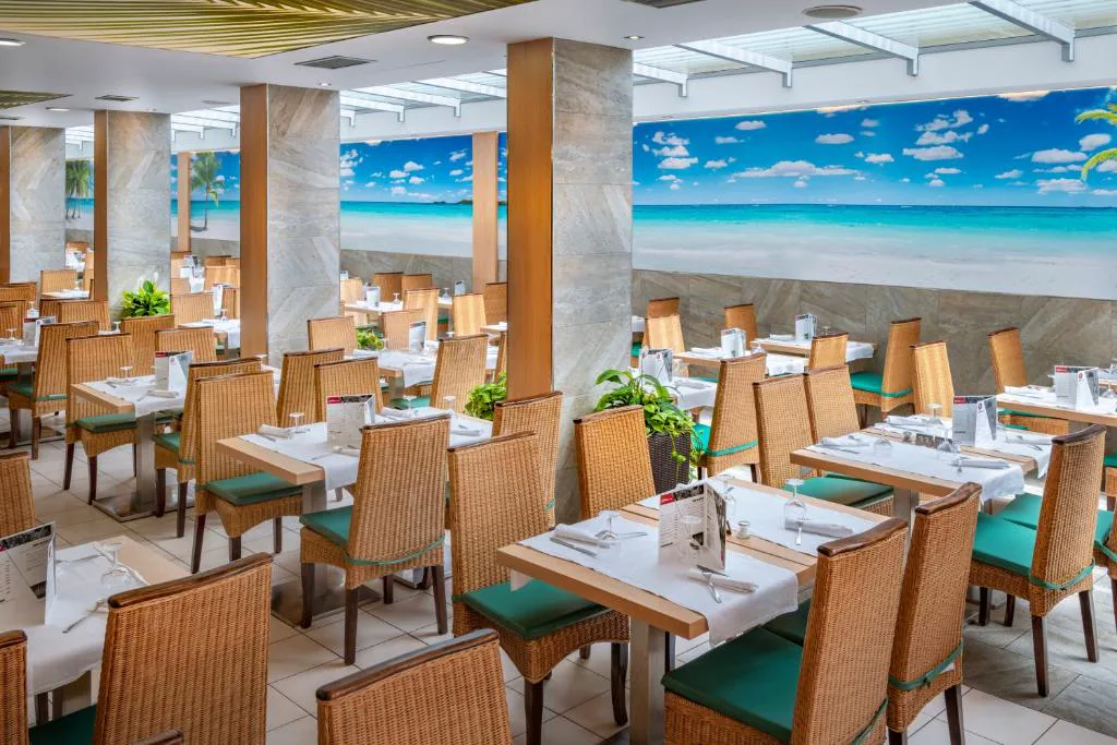 Restaurante con mesas y mural de playa