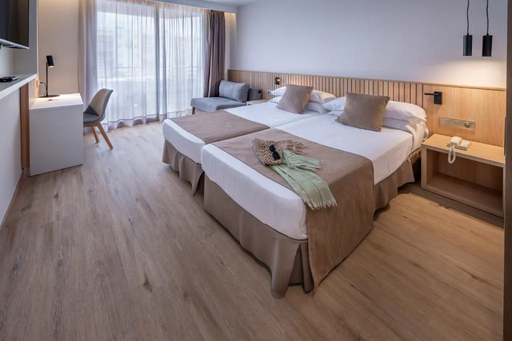 Habitación con camas juntas y sofá