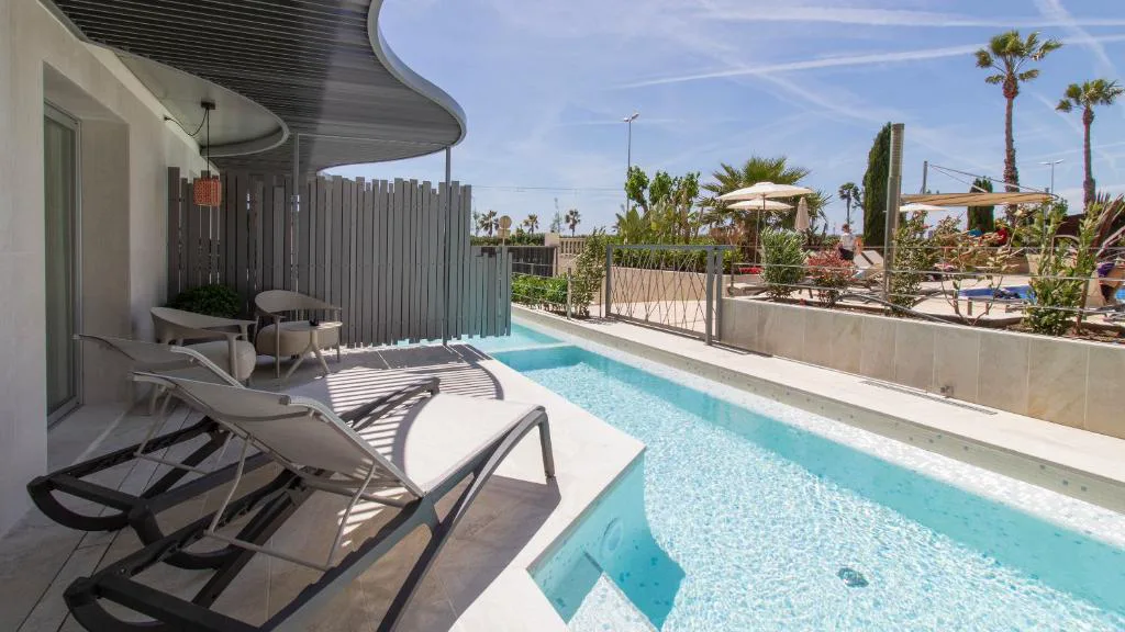 Piscina tranquila con tumbonas junto a una terraza