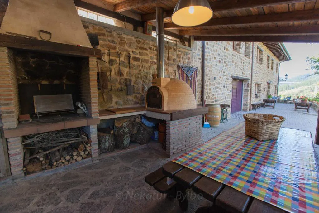 Barbacoa de obra y horno de leña bajo cubierto
