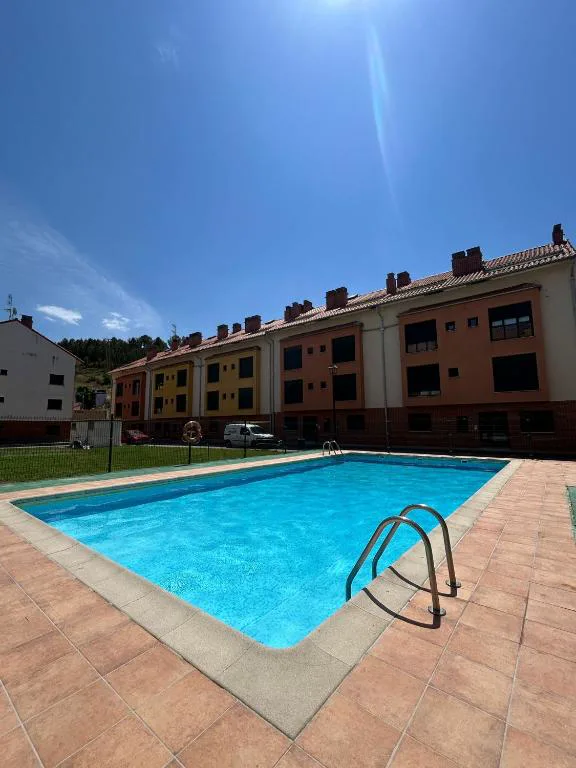 Piscina azul entre casas de ladrillo y jardines