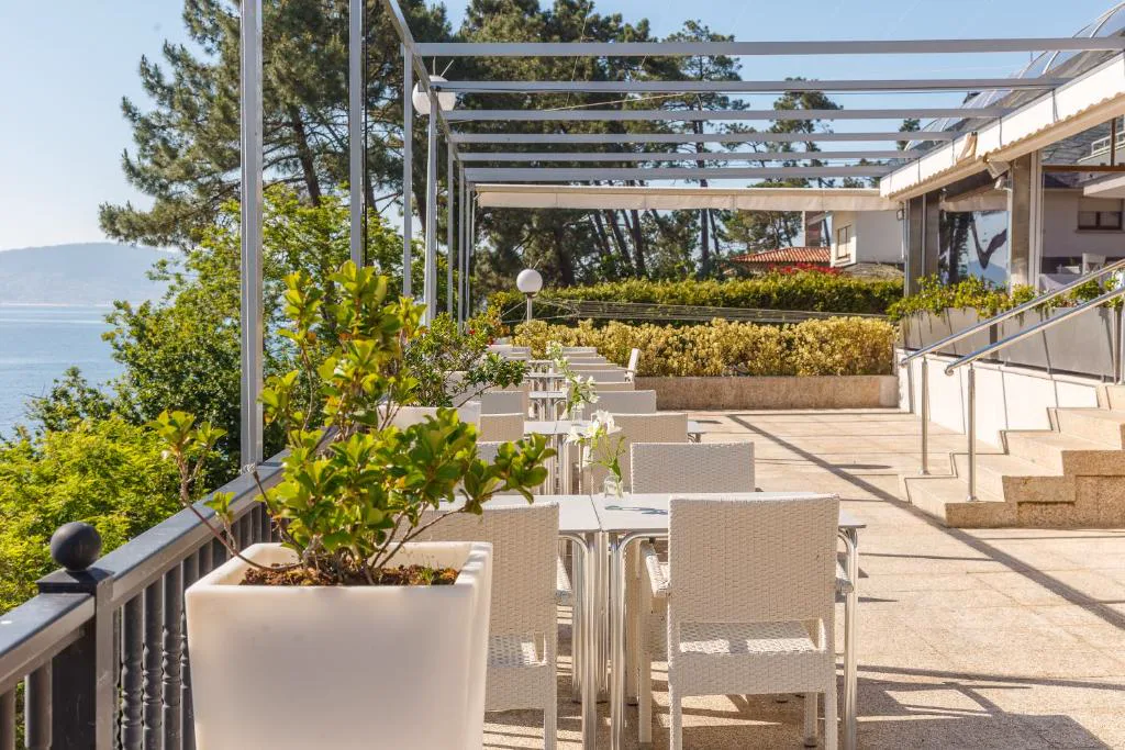 Terraza exterior con macetas y vistas a la ría entre los pinos, Gran Talaso Hotel Sanxenxo