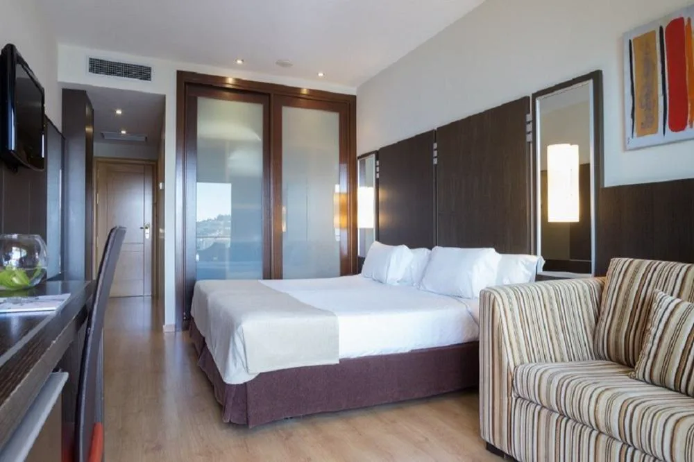 Habitación con armario acristalado y sofá de rayas junto a la cama, Gran Talaso Hotel Sanxenxo