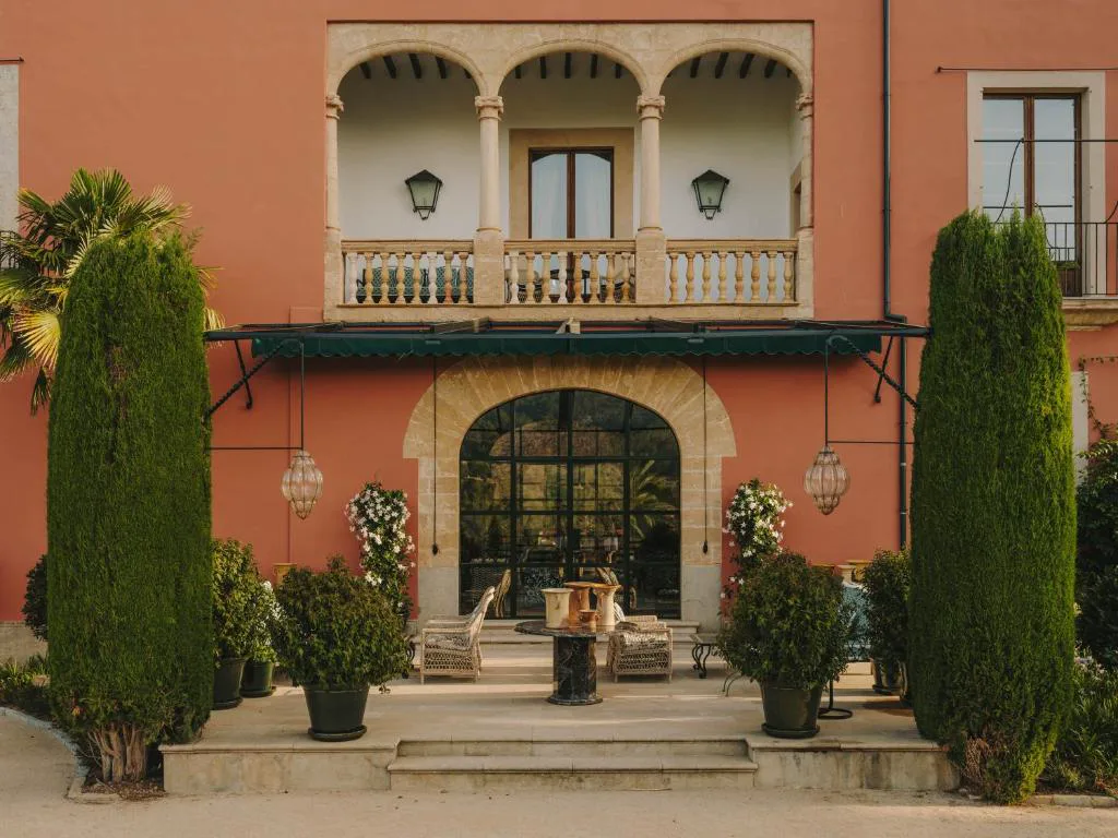 Entrada principal del palacio con balcón de piedra y patio con macetas, Grand Hotel Son Net