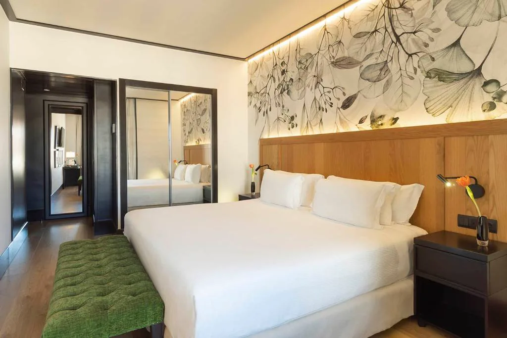 Habitación con cabecero de flores y banco verde