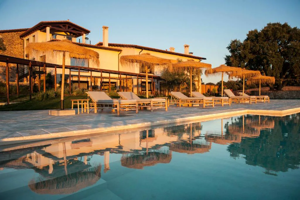 Piscina larga junto a un hotel de tejas rojas