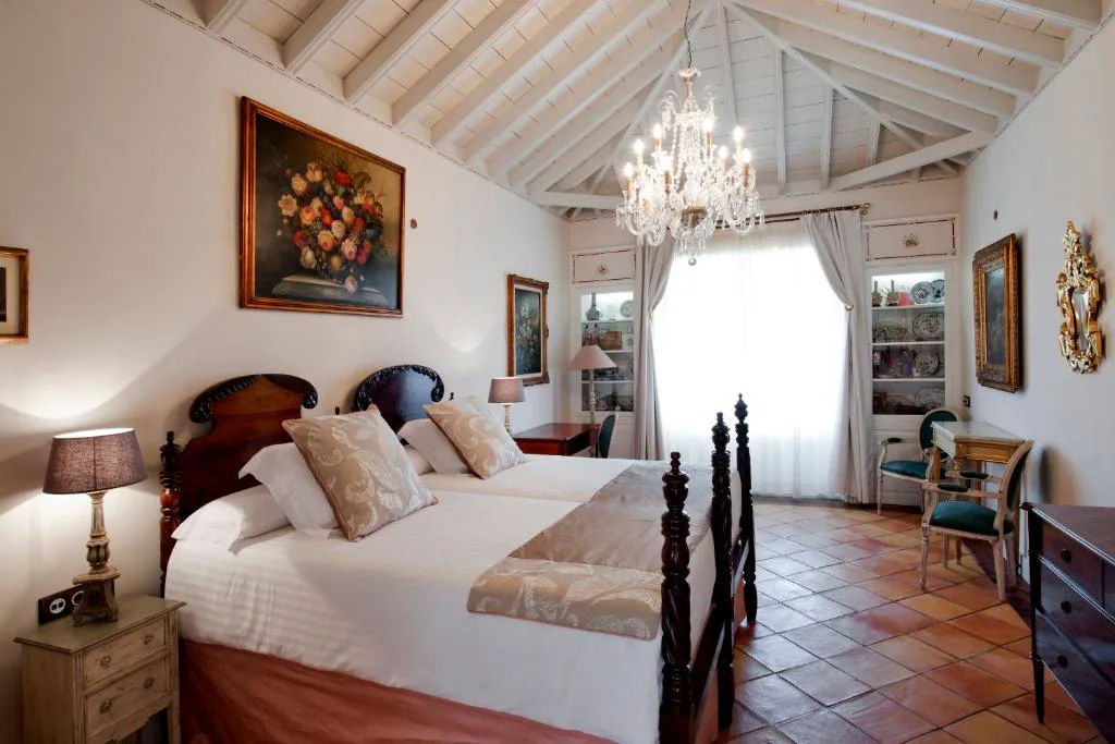 Dormitorio con techo de madera vista y candelabro de cristal, Hacienda de Abajo
