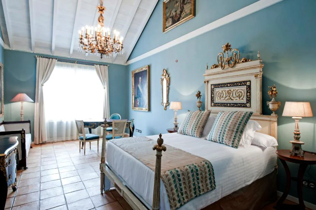 Dormitorio de paredes azules con cama dorada y candelabro, Hacienda de Abajo