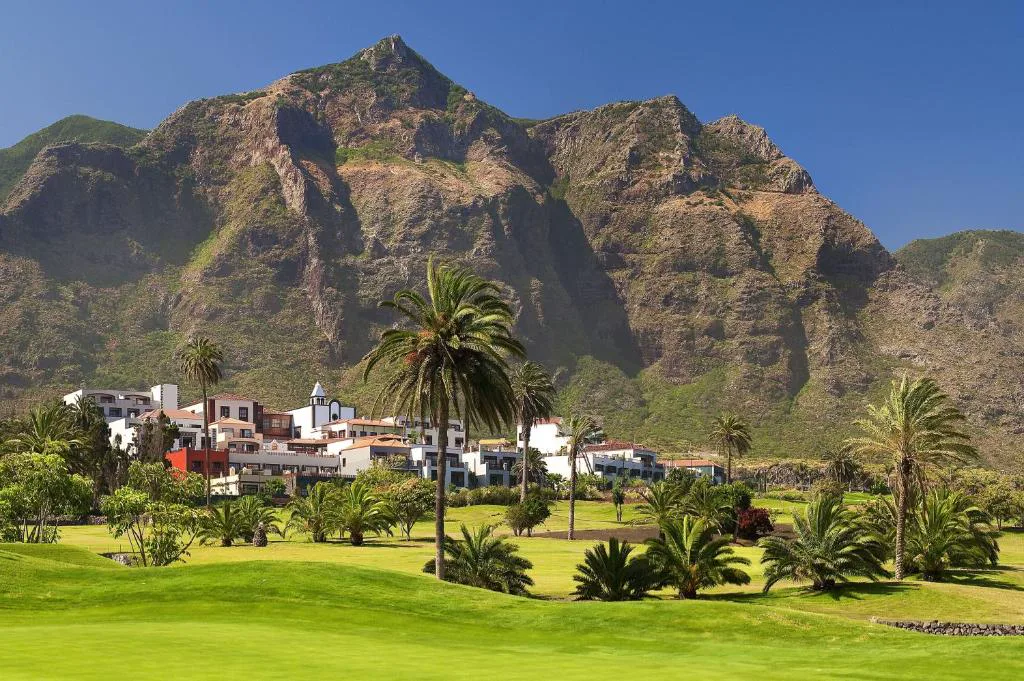 Fachada del hotel con macizo montañoso de Teno al fondo entre palmeras, Hacienda del Conde