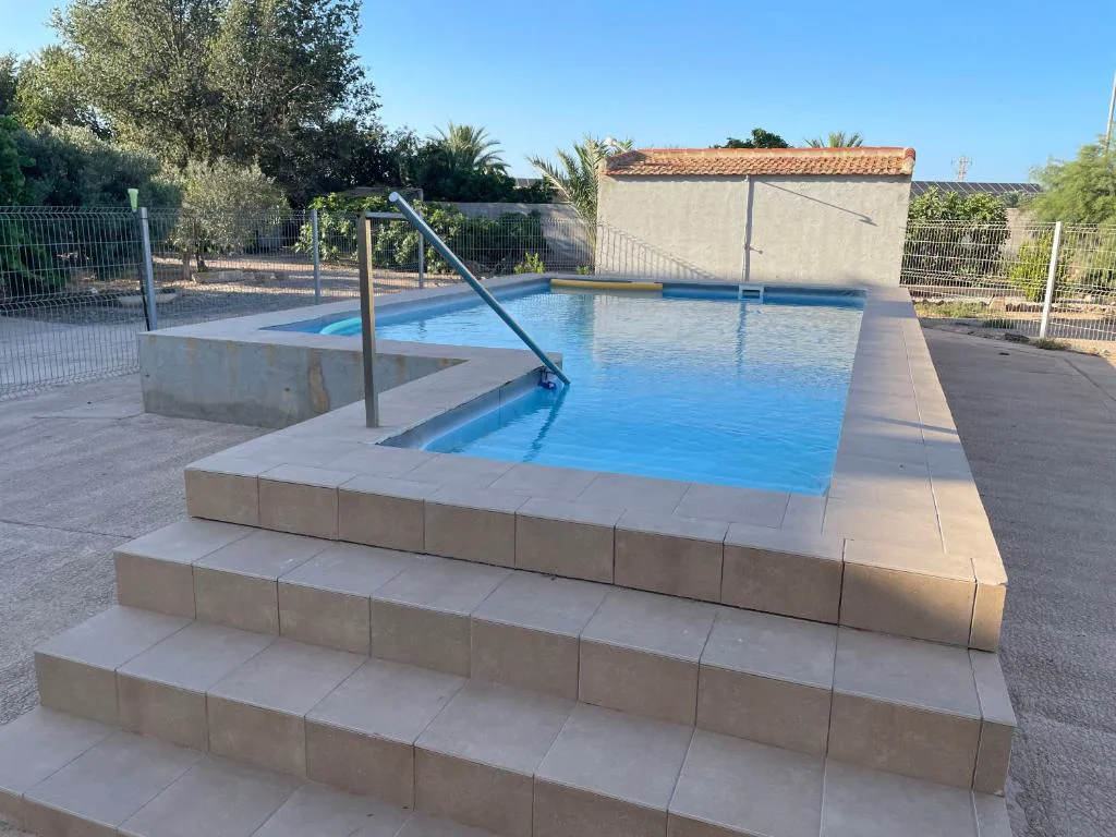 Piscina rectangular con escalones de piedra en un patio