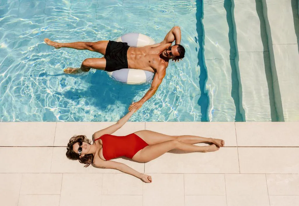 Piscina con escalones y dos personas flotando