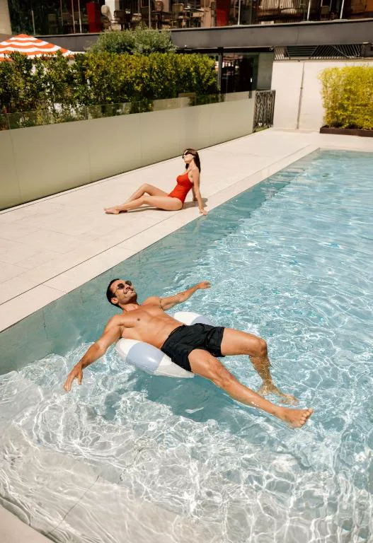 Piscina alargada con tumbona en el borde
