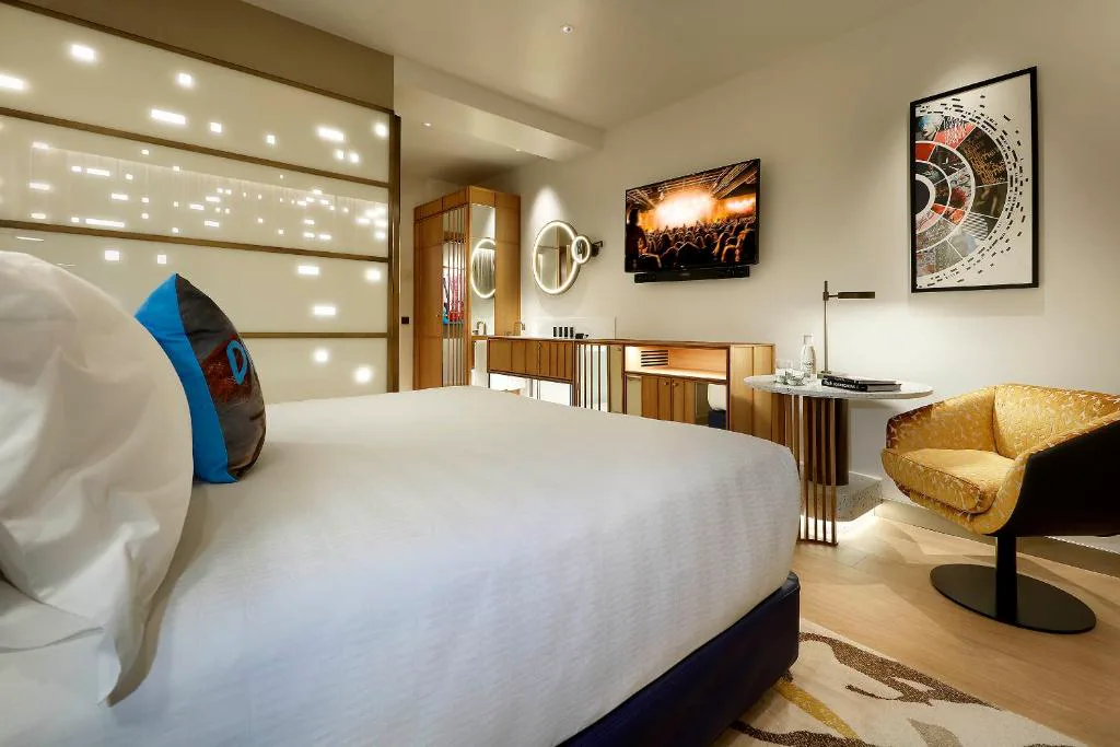 Habitación con cabecero acolchado y vitrina de guitarras
