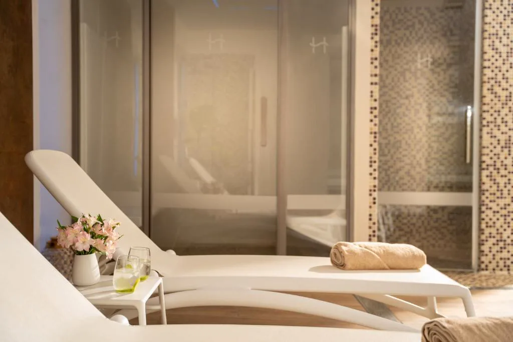 Sala del spa con tumbonas y ducha de piedra
