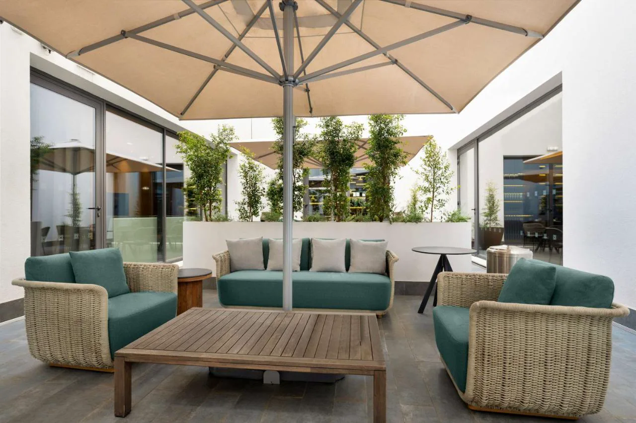 Terraza con sofás de mimbre en Hilton Porto Gaia