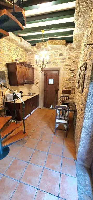 Cocina rústica de piedra con escalera de caracol y vigas verdes, Hórreo Lar San Adrián