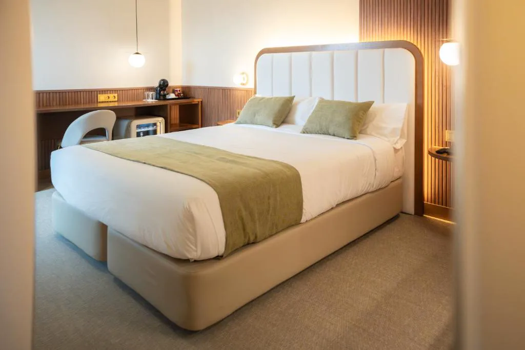 Habitación con cama grande y cabecero blanco