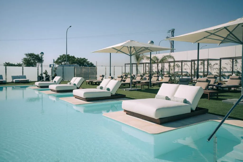 Piscina con camas balinesas junto al agua