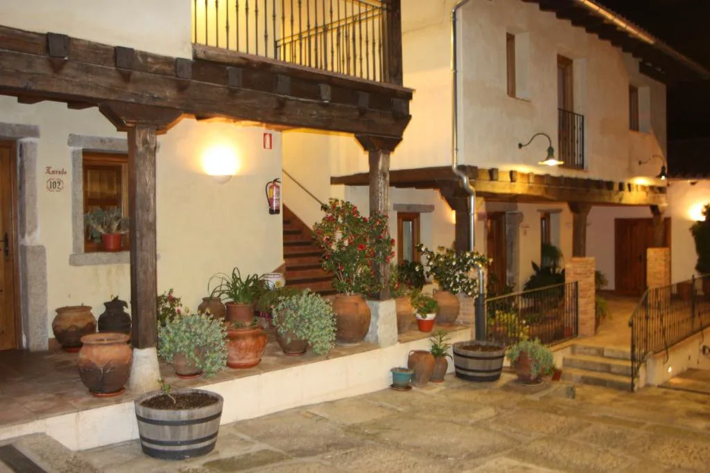 Patio de una casa señorial con balcones de madera y macetas