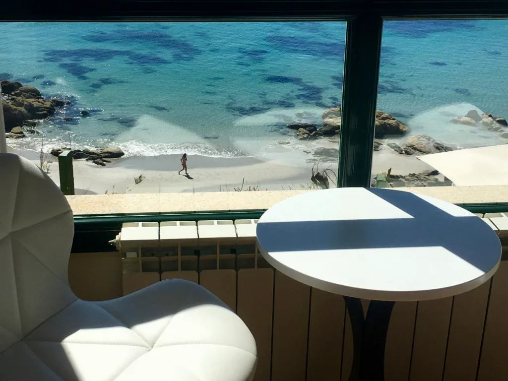 Rincón con mesa y butaca frente a la ventana con vistas a la playa, Hostal Casa Aurita Adults Only