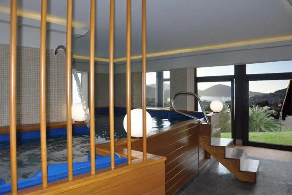 Jacuzzi interior con chorros y vistas al mar y las montañas de Cedeira, Hostal Meson Leira Antiga