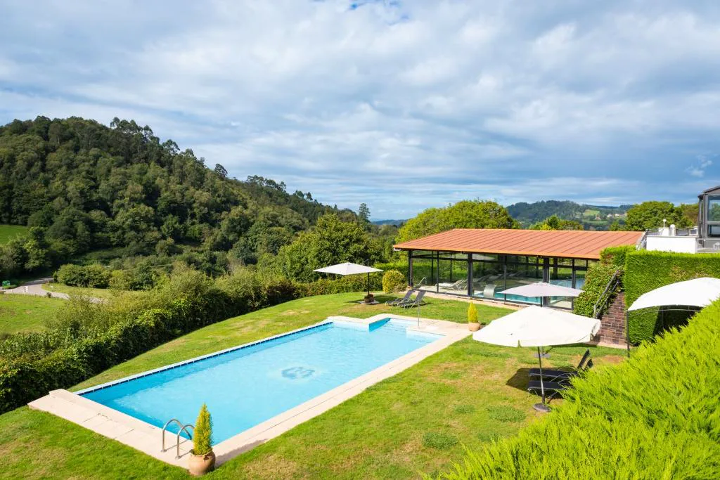Piscina exterior panorámica con vistas a las montañas en Hosteria de Torazo