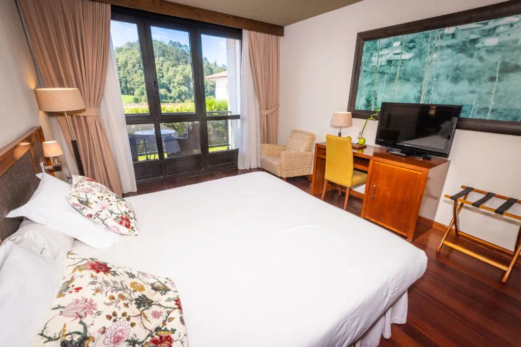 Habitación con vistas al jardín y cuadro de paisaje marino en Hosteria de Torazo