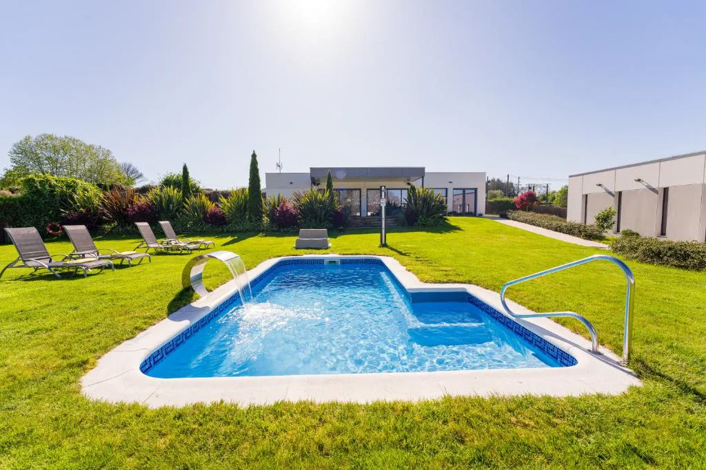 Piscina exterior con tumbonas y arquitectura moderna, Hotel A Curuxa Wellness