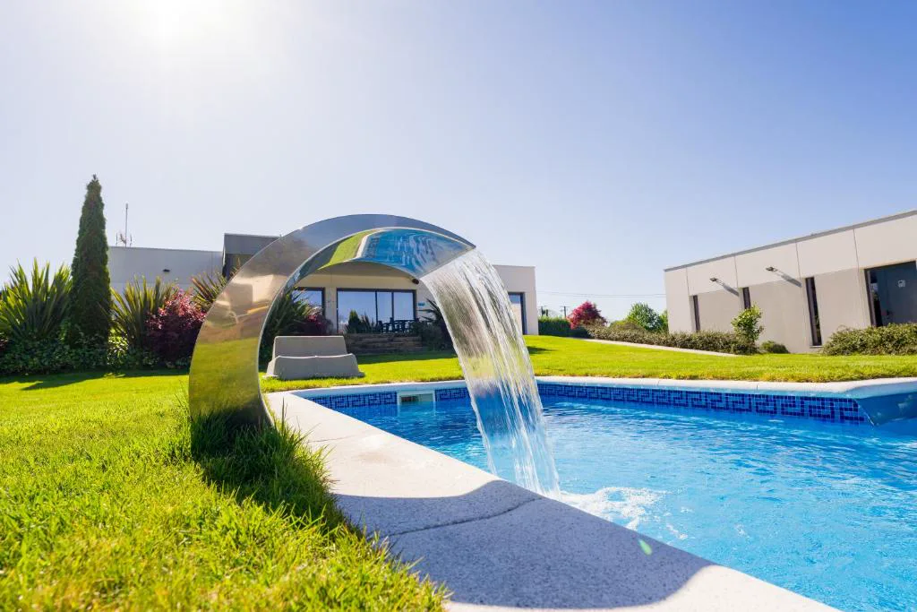 Piscina exterior con cascada de diseño de acero inoxidable, Hotel A Curuxa Wellness