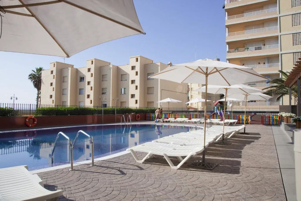 Piscina exterior con sombrillas blancas
