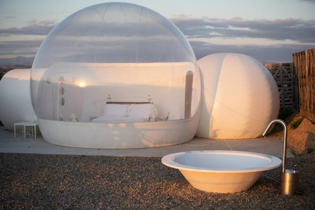 Habitación burbuja transparente con bañera y vistas al cielo