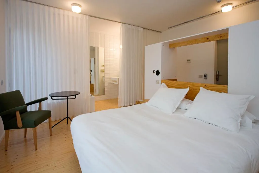Habitación con cabecero de madera y cama blanca