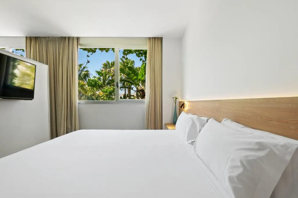 Habitación con cama doble y ventana al jardín