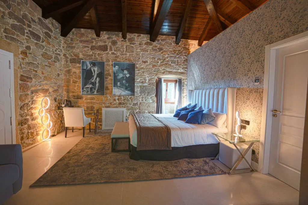 Habitación con techos de madera vista y paredes de piedra original, Hotel As Torres da Hermida